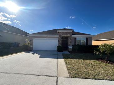 One-story house with a two-car garage and a well-manicured lawn at 1038 Suffragette Cir, Haines City, FL 33844