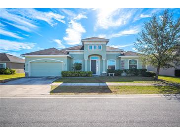 Beautiful light green house with a three-car garage and well-manicured lawn at 1836 James Towne Ln, Bartow, FL 33830