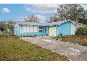 Cute blue house with a yellow garage door and well-maintained lawn at 2304 Honey Dr, Lakeland, FL 33801