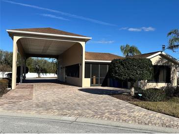 Tan house with covered carport and landscaped yard at 265 Laynewade Rd, Polk City, FL 33868