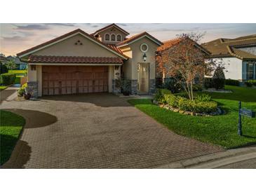 Brick paver driveway leads to a charming two-story home with a large garage at 2961 Sanctuary Cir, Lakeland, FL 33803