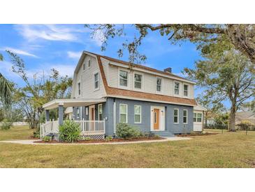 Two story renovated home with gray siding, brown roof, and a front porch at 3220 Clubhouse Rd, Lakeland, FL 33812