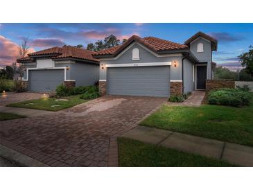 Two-story home with gray exterior, tile roof, and brick paver driveway at 4108 Solamor St, Lakeland, FL 33810