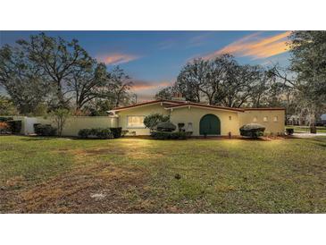 Ranch style home with large green door and mature trees at 513 E Highland Dr, Lakeland, FL 33813