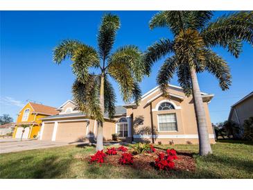 Beautiful home with palm trees and well-manicured lawn at 518 Grand Reserve Dr, Davenport, FL 33837