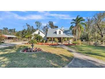 A charming single-story home with metal roof, landscaping, and a long driveway at 7030 Klein Rd, Lakeland, FL 33813