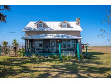 Country home with metal roof, porch swing, and expansive yard at 7275 Lake Hendry Rd, Fort Meade, FL 33841