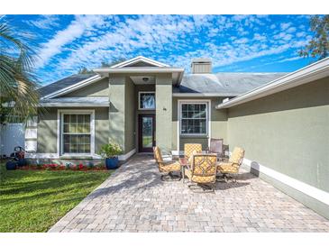 Green house with paver patio, landscaping, and a two-car garage at 781 Sagewood Dr, Lakeland, FL 33813