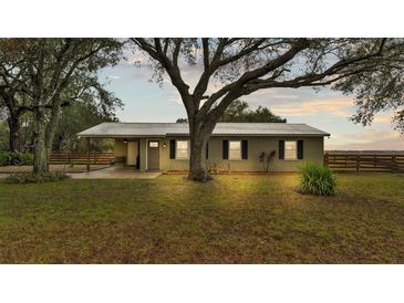 Newly renovated ranch home with a metal roof and large oak trees at 9585 Shreck Rd, Bartow, FL 33830