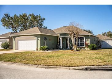 One-story house with a green exterior, white garage door, and landscaping at 1012 Robin Ln, Winter Haven, FL 33884