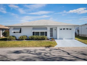 White single story home with attached garage and landscaped front yard at 4854 Colonnades Club Blvd, Lakeland, FL 33811