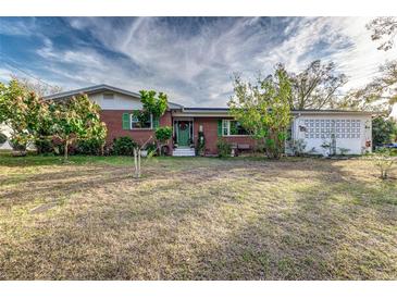 Brick ranch home with green door, mature landscaping, and spacious yard at 518 Boger N Blvd, Lakeland, FL 33803