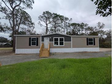 Charming single-story home featuring a neatly maintained lawn, neutral-tone siding, and a welcoming front entrance with new steps at 8807 Carrolwood Dr, Lakeland, FL 33810