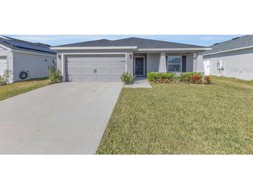 Well-maintained single-story home featuring a manicured lawn and a two-car garage at 1065 Silas St, Haines City, FL 33844