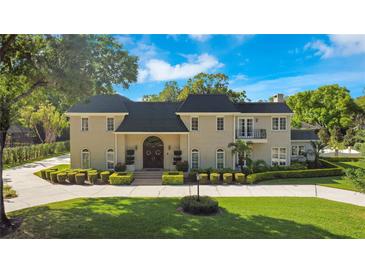 Brick home with a large front yard, circular driveway and mature landscaping at 1419 Hollingsworth Oaks Dr, Lakeland, FL 33803