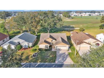 Charming home with a well-manicured front lawn and long driveway situated near a lush green golf course at 6228 Crane Dr, Lakeland, FL 33809