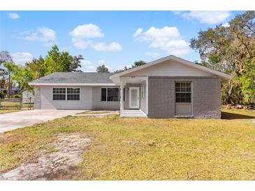 Newly renovated home with gray brick exterior, landscaped yard, and a covered porch at 815 N Hendry Ave, Fort Meade, FL 33841