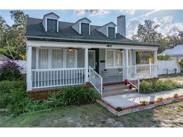 Charming two-story home featuring a cozy front porch with white railings and well-manicured landscaping at 1841 Casco St, Lakeland, FL 33801