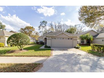 Charming single-story home featuring a well-manicured lawn and two-car garage at 1961 Rocky Pointe Dr, Lakeland, FL 33813