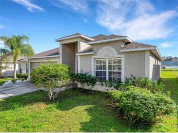 Charming single-story home boasts lush landscaping and a well-maintained lawn under a sunny sky at 2454 Harrison Place Blvd, Lakeland, FL 33810