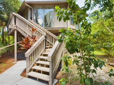 Elevated home with wooden stairs and surrounding lush greenery at 2907 Marion Way # 2907, Haines City, FL 33844