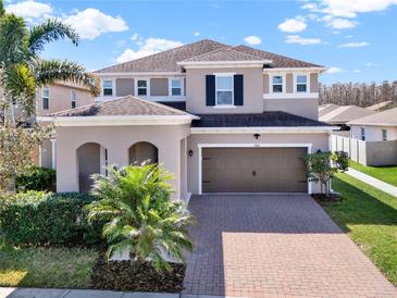 Charming two-story home featuring a brick driveway, a two-car garage, and well-maintained landscaping at 3460 Canvas St, Kissimmee, FL 34741