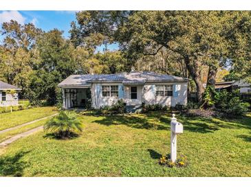 Charming single story home with a well maintained lawn, mature trees, and blue shutters at 424 S Elm Rd, Lakeland, FL 33801
