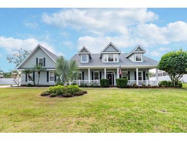 Charming single-Gathering home featuring a welcoming front porch, lush lawn, and manicured landscaping for great curb appeal at 5155 Lake Deeson Woods Ct, Lakeland, FL 33805