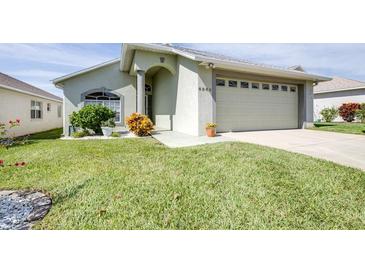 Inviting single-story home featuring well-manicured lawn, two-car garage, and meticulously maintained landscaping at 6962 Starmount Dr, Lakeland, FL 33810