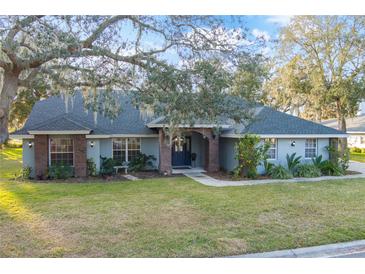 Charming single-story home featuring mature landscaping and a welcoming brick-accented entryway at 7026 Parliament Pl, Lakeland, FL 33809