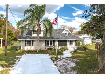 Charming home with a well-manicured lawn, a palm tree, and an American flag at 1290 S Mcadoo Ave, Bartow, FL 33830