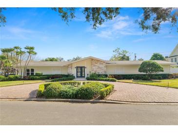 Stunning home with a lush front yard, beautiful landscaping, and a circular brick driveway at 1401 Easton Dr, Lakeland, FL 33803