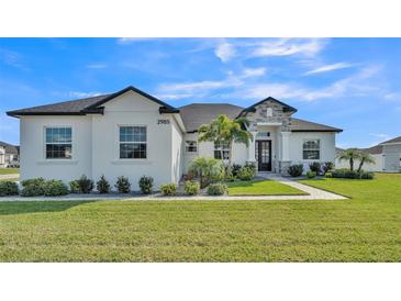 Beautiful one-story home with a well-manicured lawn, featuring a stone accent entryway, and decorative landscaping at 2985 Pickards Pass, Lakeland, FL 33813