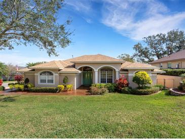 Landscaped front yard featuring a charming home with a well-manicured lawn and lush plantings at 324 Lake Mariam Blvd, Winter Haven, FL 33884