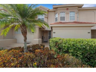 Two story tan home featuring a palm tree and manicured bushes at 417 Enclave Pl # 2, Lakeland, FL 33803