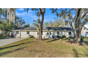 Charming single-story home with mature trees and a well-manicured front lawn at 4601 Sw Reynosa Sw Dr, Winter Haven, FL 33880