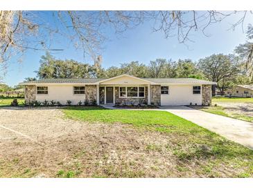 Charming single-story home with stone accents, fresh paint and a spacious front yard at 5908 Lunn Rd, Lakeland, FL 33811