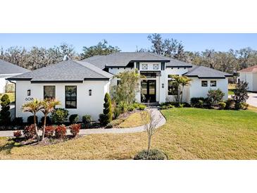 Beautiful single Gathering home showcasing the professionally landscaped front yard and modern architecture at 6018 Abbey Oaks Dr, Lakeland, FL 33811