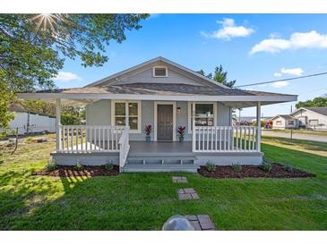 Charming home with a large front porch, fresh landscaping and a welcoming walkway at 602 E Orange St, Auburndale, FL 33823