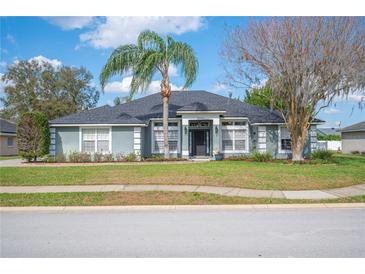 Charming single-story home with mature landscaping, blue siding, and a well-manicured front lawn at 6846 Ashbury Dr, Lakeland, FL 33809