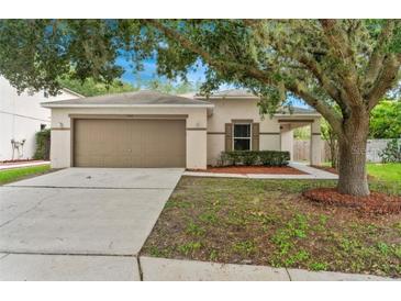 Charming single-story home featuring a well-maintained lawn, mature landscaping, and a two-car garage at 7444 Hunters Greene Cir, Lakeland, FL 33810