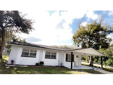 Charming one-story home with a covered porch, white exterior, and well-manicured lawn at 745 4Th St, Polk City, FL 33868