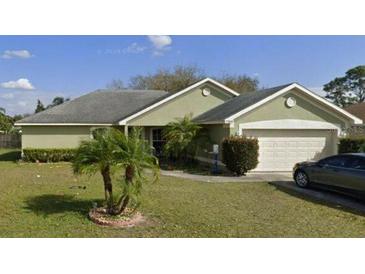 Charming single-story home featuring a well-manicured lawn and a two-car garage with mature landscaping at 7704 Canterbury Cir, Lakeland, FL 33810