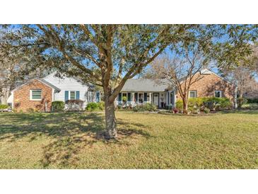 Charming one-story home with a manicured lawn, mature landscaping, and inviting front porch at 860 Lila St, Bartow, FL 33830