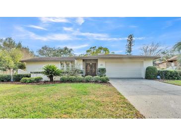 Charming single story home featuring a lush green lawn and attached two car garage at 1047 Sugartree S Ln, Lakeland, FL 33813