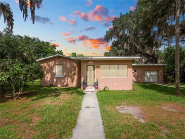 Charming single-story home featuring a quaint front yard, walkway and mature tree coverage at 116 S Lanier Ave, Fort Meade, FL 33841