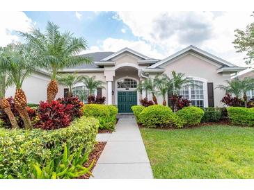 Charming one-story home with a well-manicured lawn, lush landscaping, and a welcoming front entrance at 1808 Baltusrol Ct, Lakeland, FL 33803