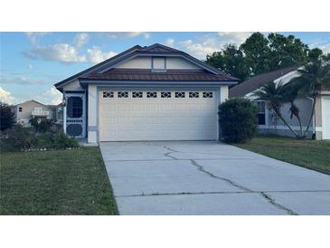 Attached two-car garage featuring decorative windows and a concrete driveway at 2021 Windward Pass, Lakeland, FL 33813