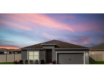 Charming single-story home featuring neutral tones and a two-car garage against a beautiful sky at 211 Emanuelle Dr, Winter Haven, FL 33884