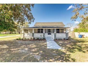 Charming single-story home featuring a cozy front porch with white railings and manicured landscaping at 22 S Cherokee Ave, Fort Meade, FL 33841